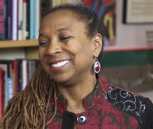 Head shot of Kimberle Williams Crenshaw in her office looking to the left and smiling